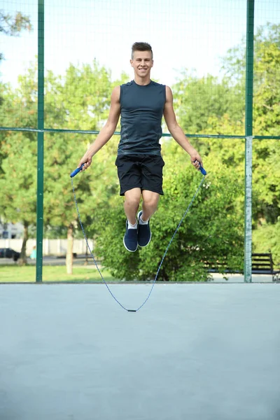 Giovane uomo sportivo saltare corda all'aperto — Foto Stock