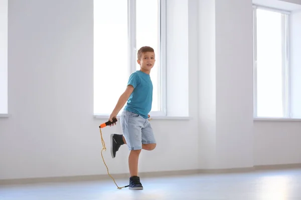 Adorable boy skipping rope indoors — Stock Photo, Image