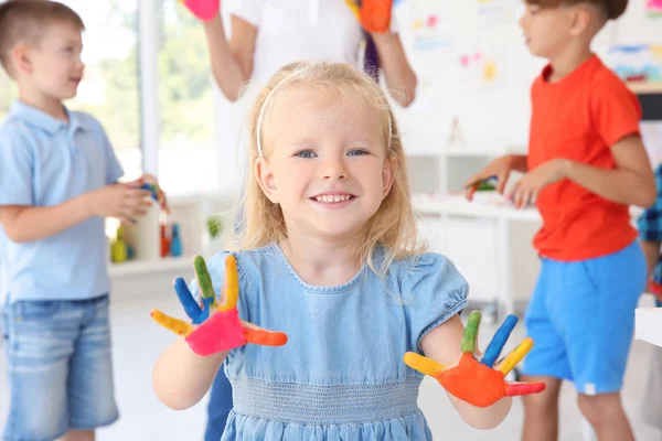 Маленька дівчинка з руками в фарбі на уроці мистецтва — стокове фото
