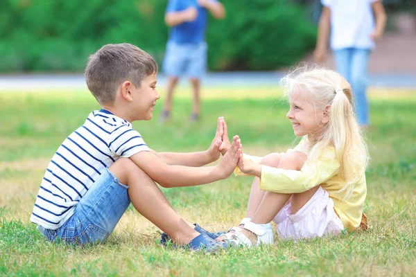 Anak laki-laki dan perempuan lucu bermain di rumput hijau — Stok Foto