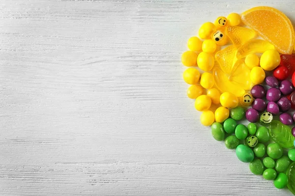 Colorful candies arranged as semi heart — Stock Photo, Image