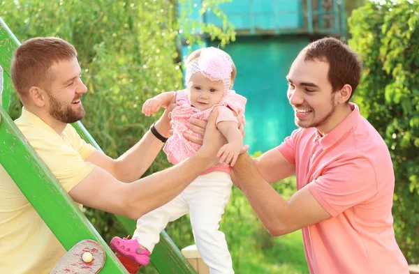 Male gay couple with adopted baby girl, outdoors — Stock Photo, Image