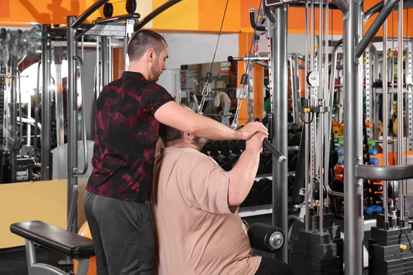 Uomo sovrappeso con allenatore in palestra — Foto Stock