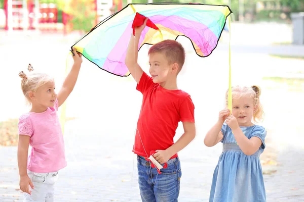 Leuke lieve kinderen met kleurrijke kite buitenshuis — Stockfoto