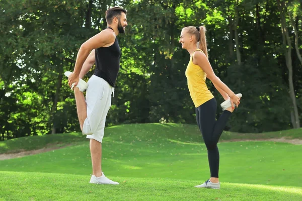 Jeune couple sportif faisant de l'exercice dans un parc vert — Photo