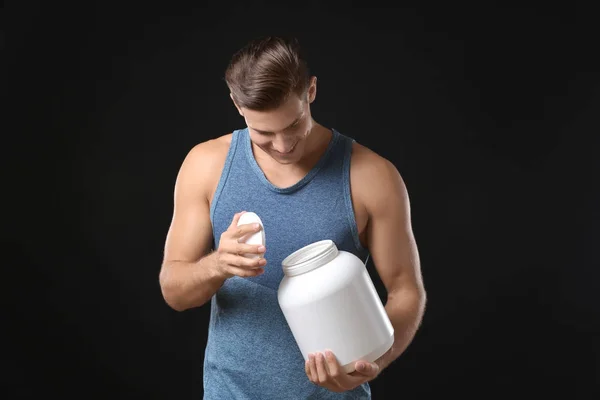 Young man holding white jar with protein powder — Stock Photo, Image