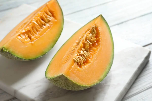 Marble board with slices of fresh ripe melon on table — Stock Photo, Image