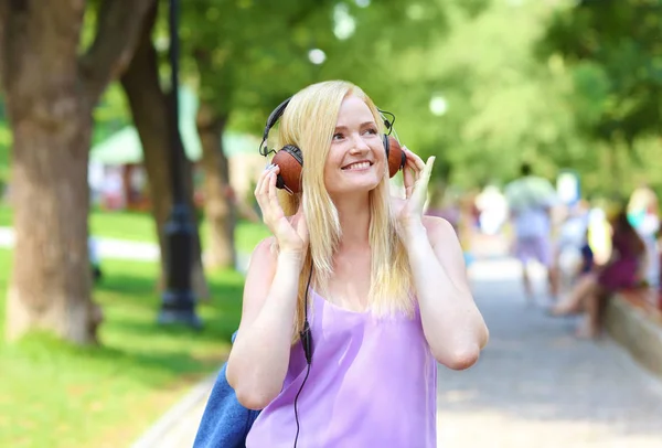Mooie jonge vrouw, luisteren naar muziek in park — Stockfoto