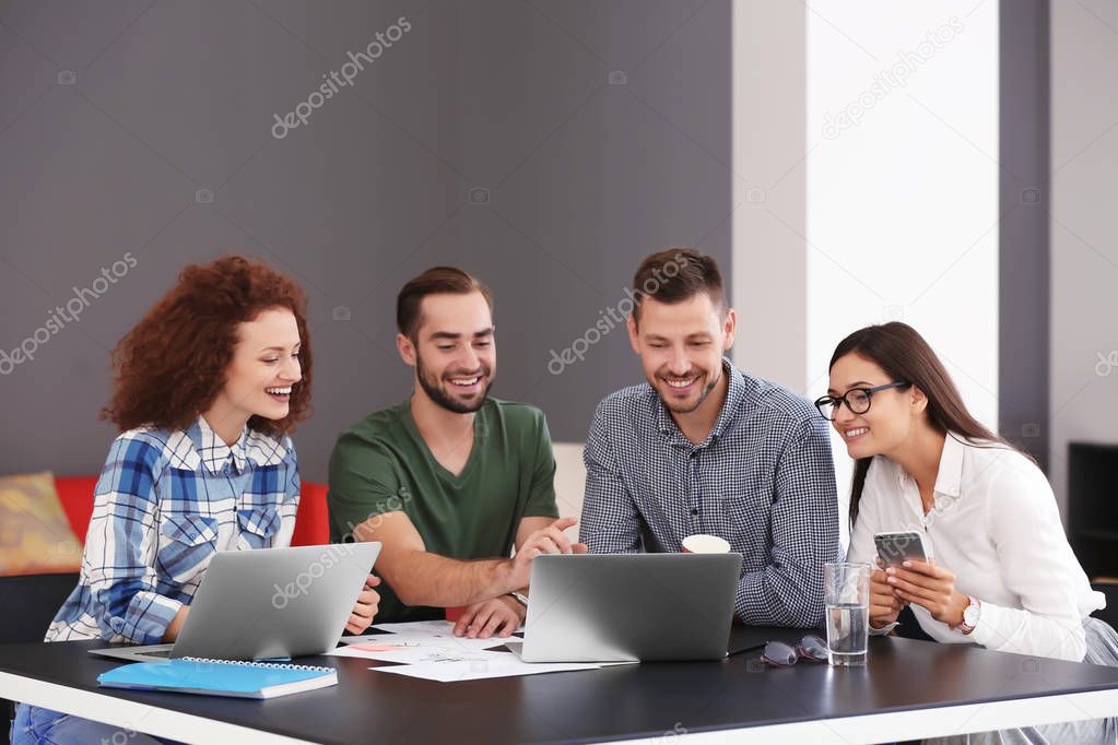 Team of young professionals conducting business meeting in office