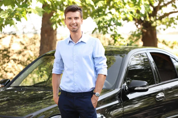 Giovane uomo d'affari in piedi vicino auto — Foto Stock