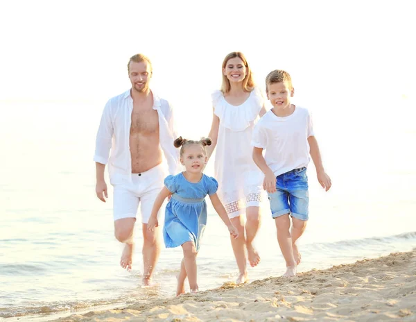 Šťastná rodina na mořské pláži v letovisku — Stock fotografie