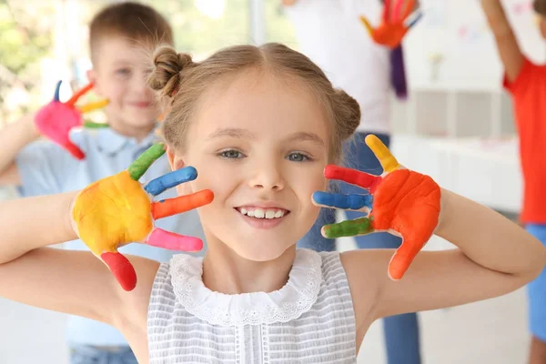 Liten flicka med händerna i paint på konst lektion — Stockfoto