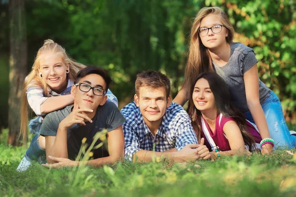 Glückliche Teenager liegen auf Gras im Park — Stockfoto