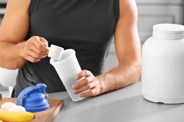 Man preparing protein shake in kitchen — Stock Photo, Image