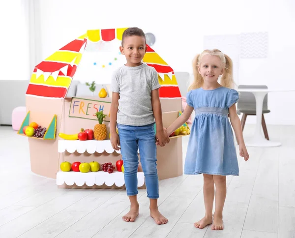Söta barn står nära counter med frukter inomhus — Stockfoto