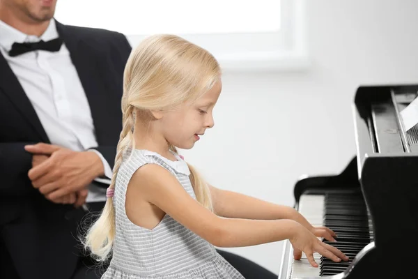 Мужчина и девочка играют на пианино — стоковое фото