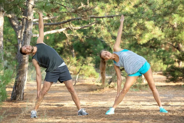 Joven hombre y mujer haciendo ejercicios en el parque — Foto de Stock
