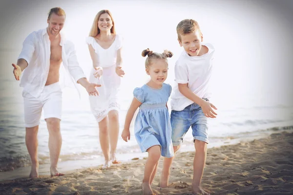 Szczęśliwa rodzina na plaży morskiej w kurorcie — Zdjęcie stockowe