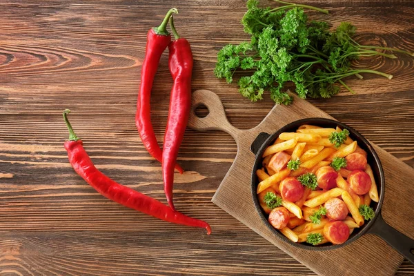 Pasta met worst in de koekenpan en fruit — Stockfoto