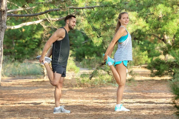 Joven hombre y mujer haciendo ejercicios en el parque — Foto de Stock