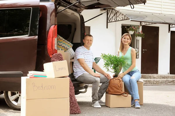 Pareja feliz con cajas móviles cerca del coche al aire libre — Foto de Stock