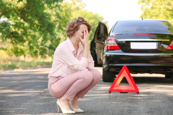 Kobieta w pobliżu jej uszkodzonego samochodu — Zdjęcie stockowe