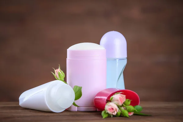 Дезодоранты для женщин и цветы на столе — стоковое фото