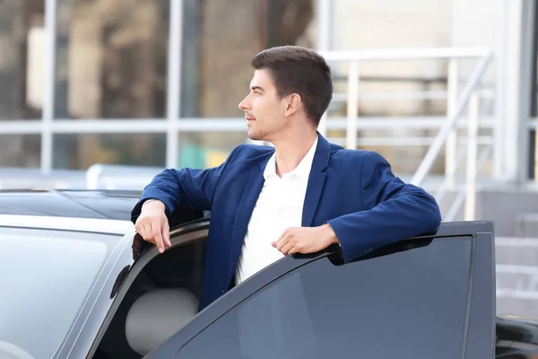 Giovane uomo d'affari in piedi vicino auto — Foto Stock