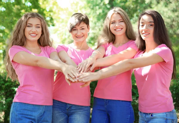 Hermosas mujeres que usan camisetas con cintas rosas, al aire libre — Foto de Stock