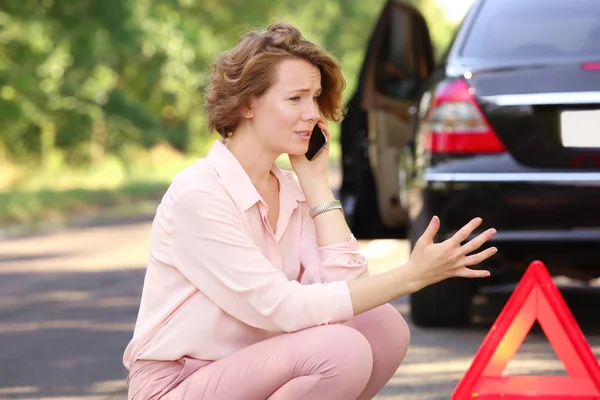 Žena poblíž její rozbité auto — Stock fotografie