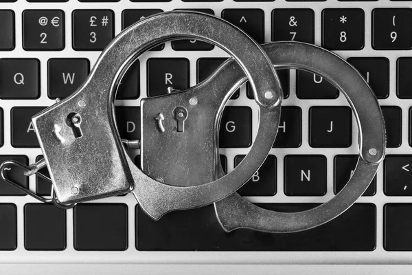 Handcuffs on laptop keyboard — Stock Photo, Image