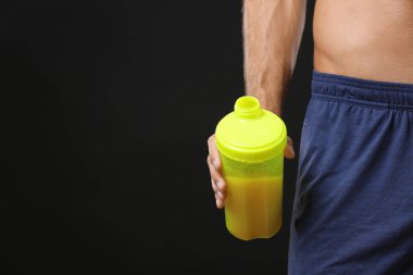 Protein shake ile şişe tutan genç adam 