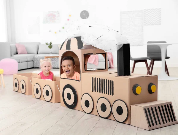 Cute children playing with cardboard train at home — Stock Photo, Image