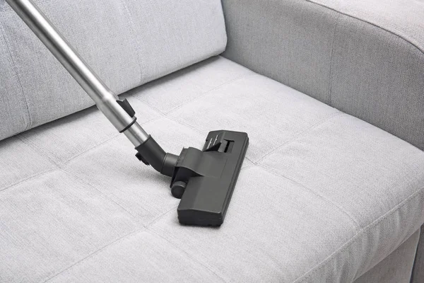 Cleaning sofa with vacuum cleaner — Stock Photo, Image