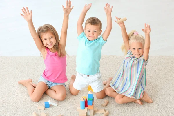 Niedliche Kinder spielen mit Bauklötzen drinnen — Stockfoto