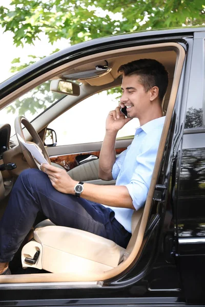 Giovane uomo d'affari che parla al telefono in auto — Foto Stock