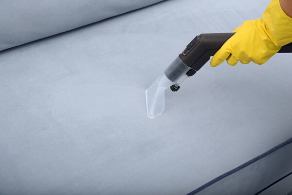 Woman cleaning couch 