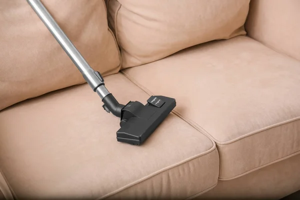 Cleaning couch with vacuum cleaner