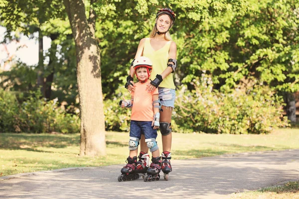 Mãe com filho em patins no parque de verão — Fotografia de Stock