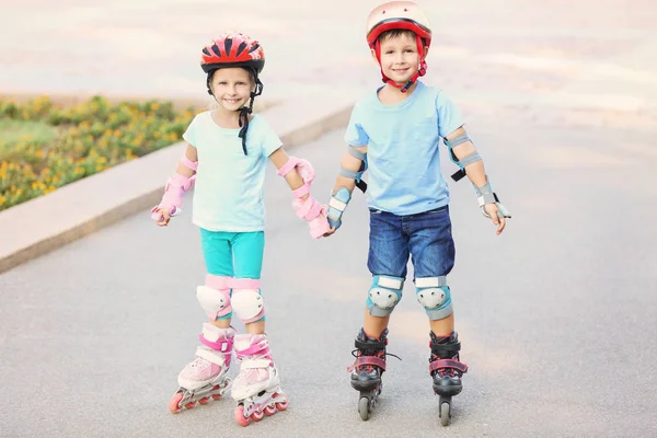 Children on roller skates in summer park — Stock Photo, Image