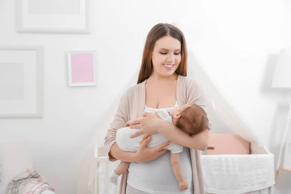 Young mother holding sleeping baby at home — Stock Photo, Image