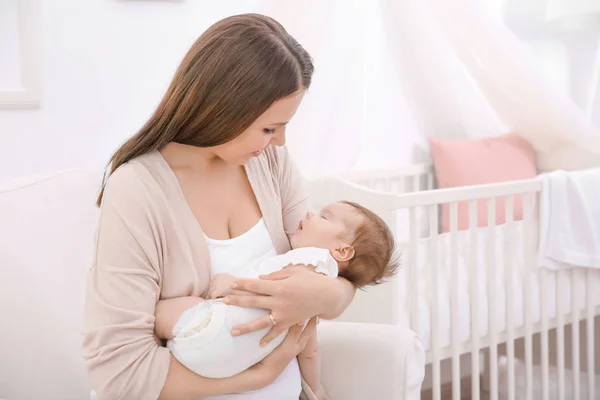 Ung mamma innehav sovande barnet hemma — Stockfoto