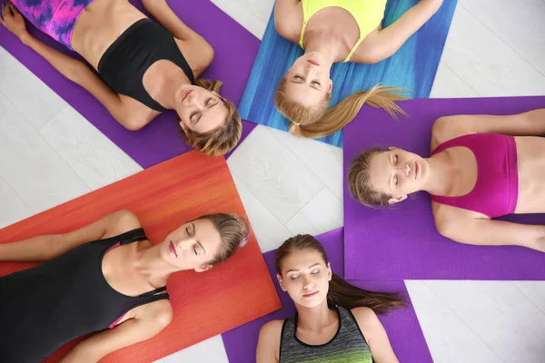 Belles jeunes femmes allongées sur des tapis de yoga dans la salle de gym — Photo