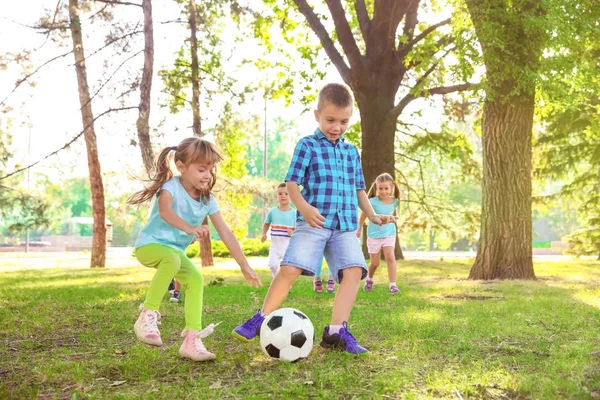 Милые маленькие дети играют с мячом в парке — стоковое фото
