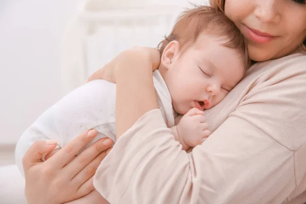 Joven madre sosteniendo durmiendo bebé en casa —  Fotos de Stock