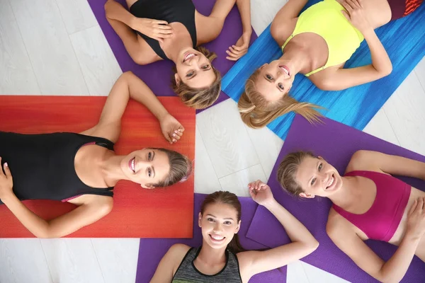 Schöne junge Frauen liegen auf Yogamatten im Fitnessstudio — Stockfoto