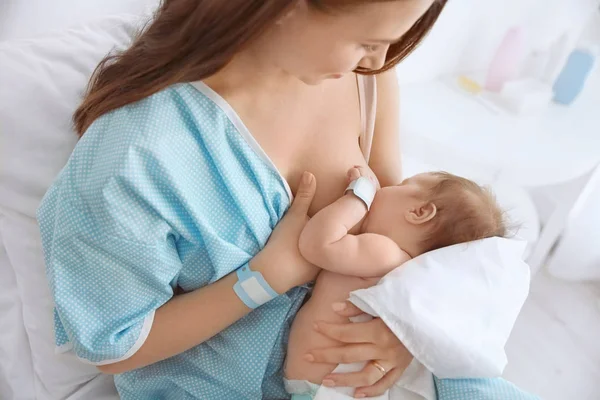 Молодая женщина кормит грудью своего ребенка в больнице — стоковое фото