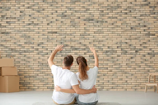Young couple sitting on floor at new home — Stock Photo, Image