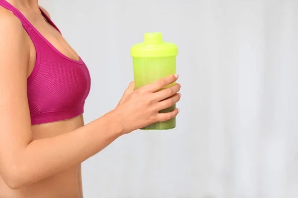 Mulher segurando garrafa com proteína — Fotografia de Stock