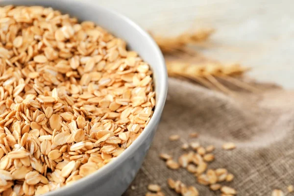 Cuenco con avena cruda en la mesa —  Fotos de Stock